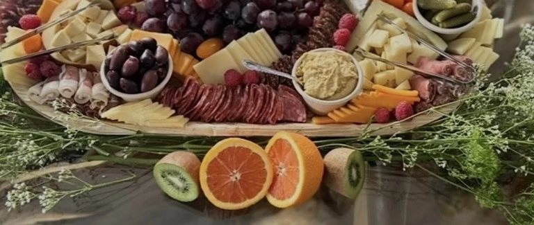 Close detail of sliced oranges and kiwi finishing the edge of a grazing board