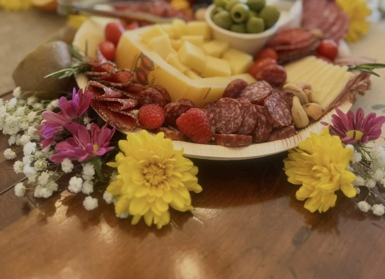 Close detail of fanned salami, raspberries and cashews